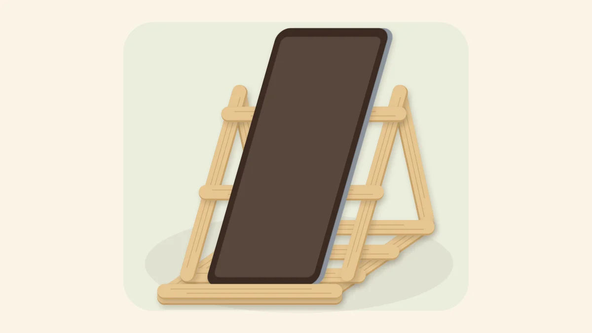 Popsicle stick phone stand with triangular sides holding a plain smartphone at an angle