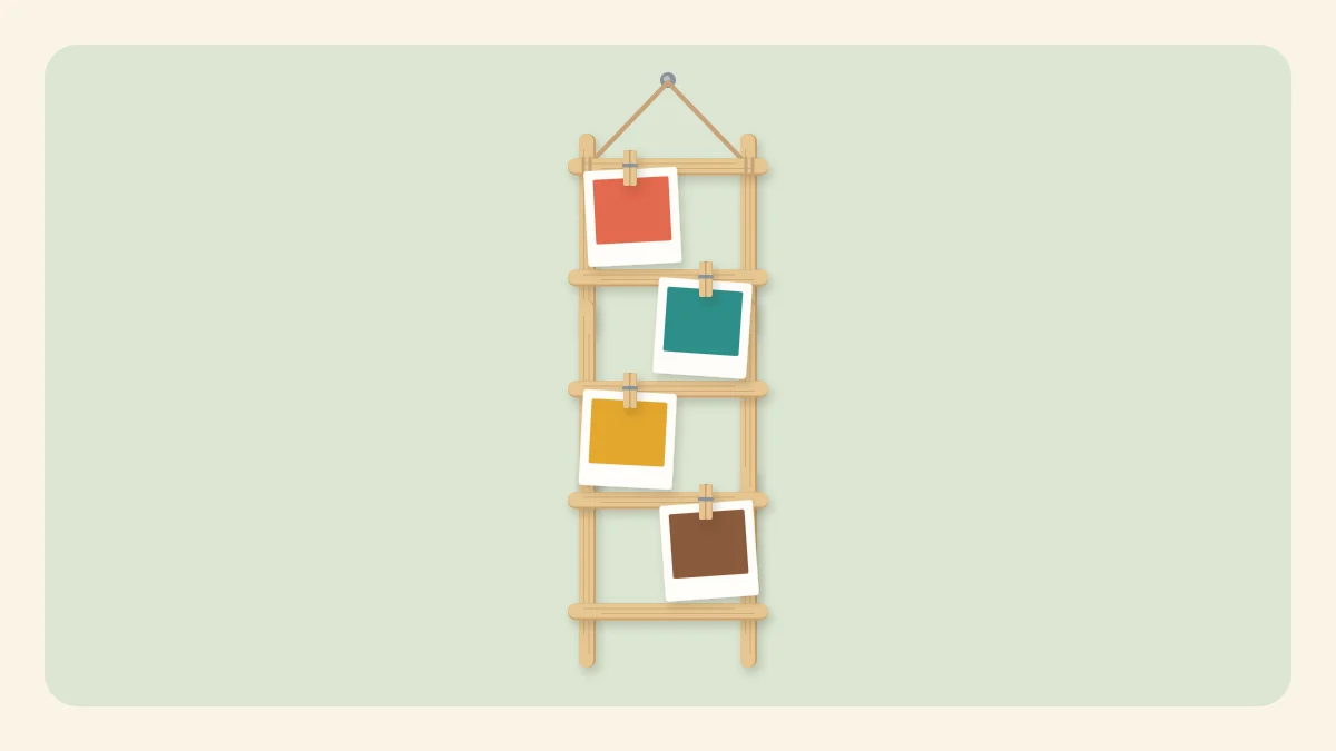 Hanging popsicle stick ladder with small photos clipped to the rungs with mini clothespins